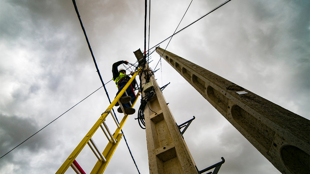 Un técnico realizando labores nun poste para a despregadura aérea da rede de fibra óptica no Concello de Oroso.